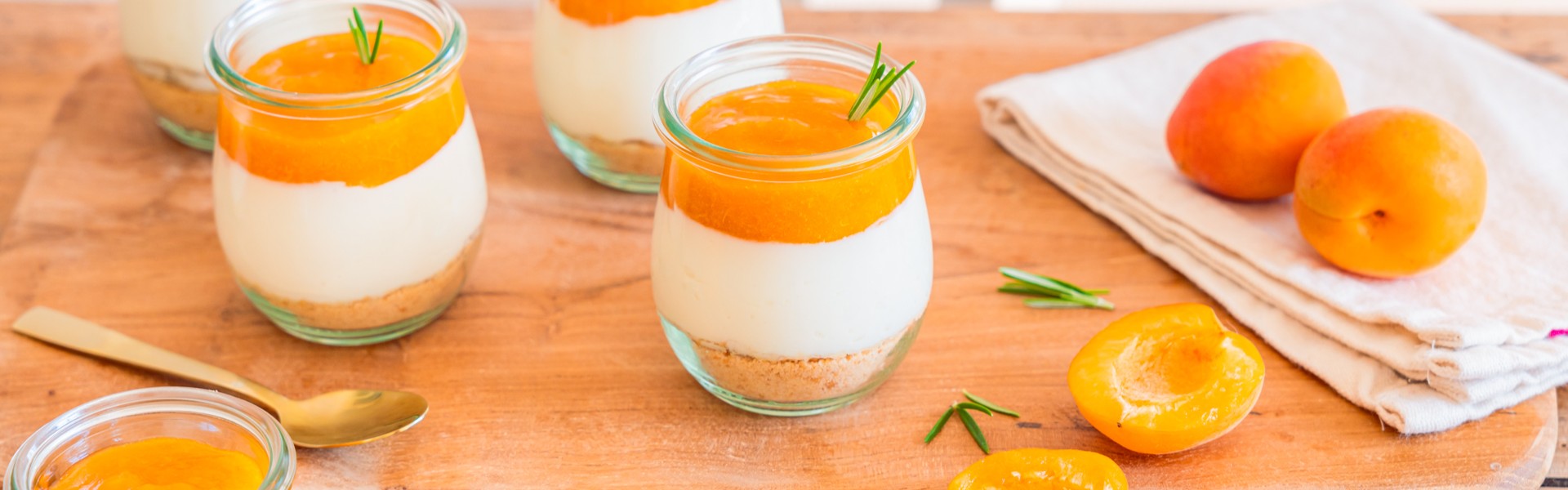 Les fruits et légumes d'été. Abricots disposé sur une table. Demis abricots et abricots entiers, accompagnés de verrines sur une table en bois.
